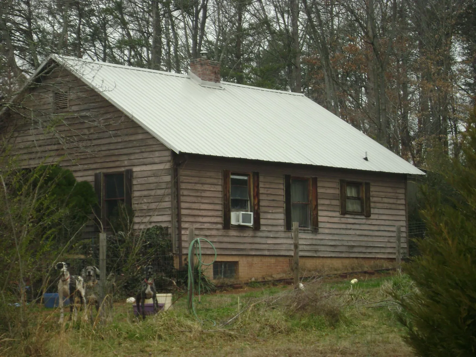 White metal roof on an old wood sided farmhouse, from a Asphalt Shingle Roof Repair job in Bessemer